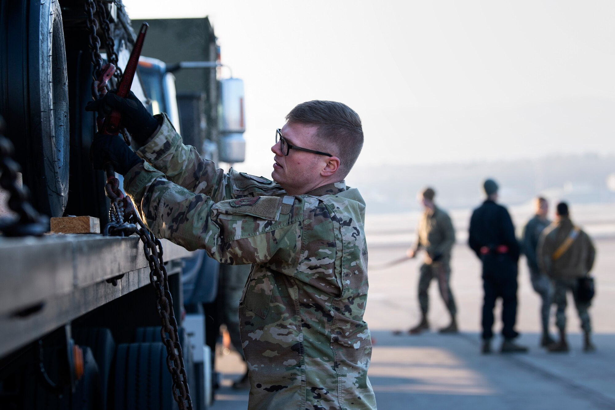 U.S. Air Force Senior Airman Austin Collier, 52nd Logistics Readiness Squadron ground transportation trainer, unhooks a chain on a trailer on the flightline at at Ramstein Air Base, Germany, Jan. 22, 2020. 52nd Fighter Wing Airmen participated in an Agile Combat Employment exercise to ensure U.S. Air Forces in Europe are ready to protect and defend allies in a moment's notice. This was the first time the 52nd FW conducted an ACE exercise at a forward-operating location. (U.S. Air Force photo by Airman 1st Class Valerie Seelye)