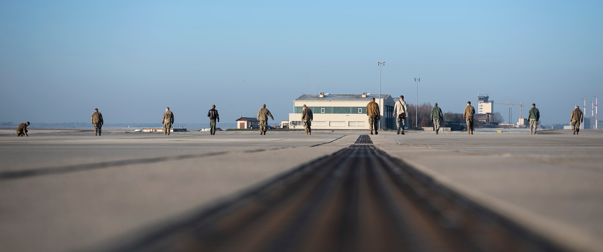 U.S. Air Force Airmen from the 52nd Fighter Wing and 86th Airlift Wing perform a foreign object debris walk on the flightline at Ramstein Air Base, Germany, Jan. 22, 2020. 52nd FW Airmen forward deployed to Ramstein to participate in an Agile Combat Employment exercise to practice moving forces fluidly in Europe and ensure readiness for any possible threat. FOD walks ensure there are no items on the flightline that could damage an aircraft. (U.S. Air Force photo by Airman 1st Class Valerie Seelye)