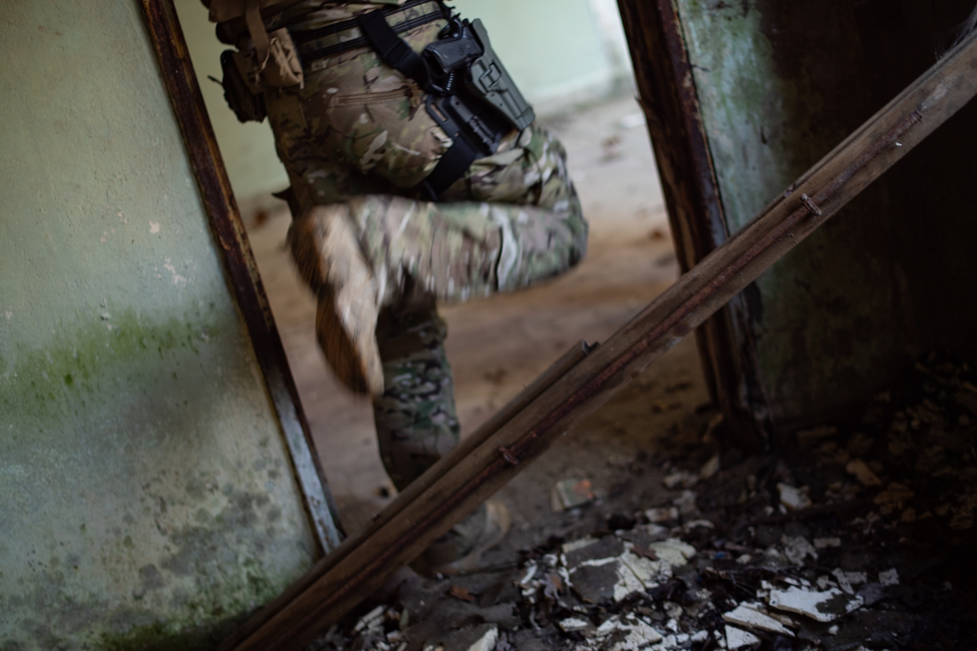 A U.S. Airman assigned to the 435th Security Forces Squadron steps over rubble while clearing a building during exercise Frozen Defender in Grostenquin, France, Jan. 16, 2020. The exercise challenged the Defenders to traverse austere environments to improve on their mission sets. (U.S. Air Force photo by Staff Sgt. Devin Boyer)