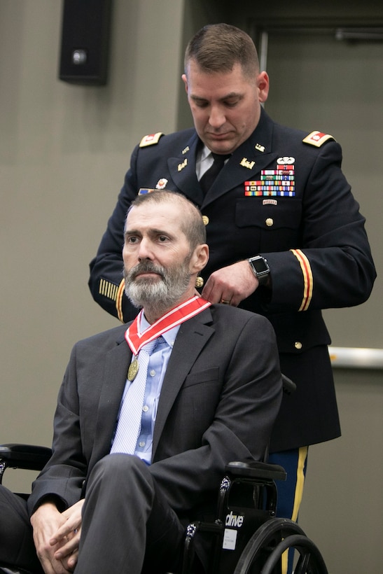 Lt. Col. Michael Harding awards the Bronze Order of the de Fleury Medal to Alex Baylot.