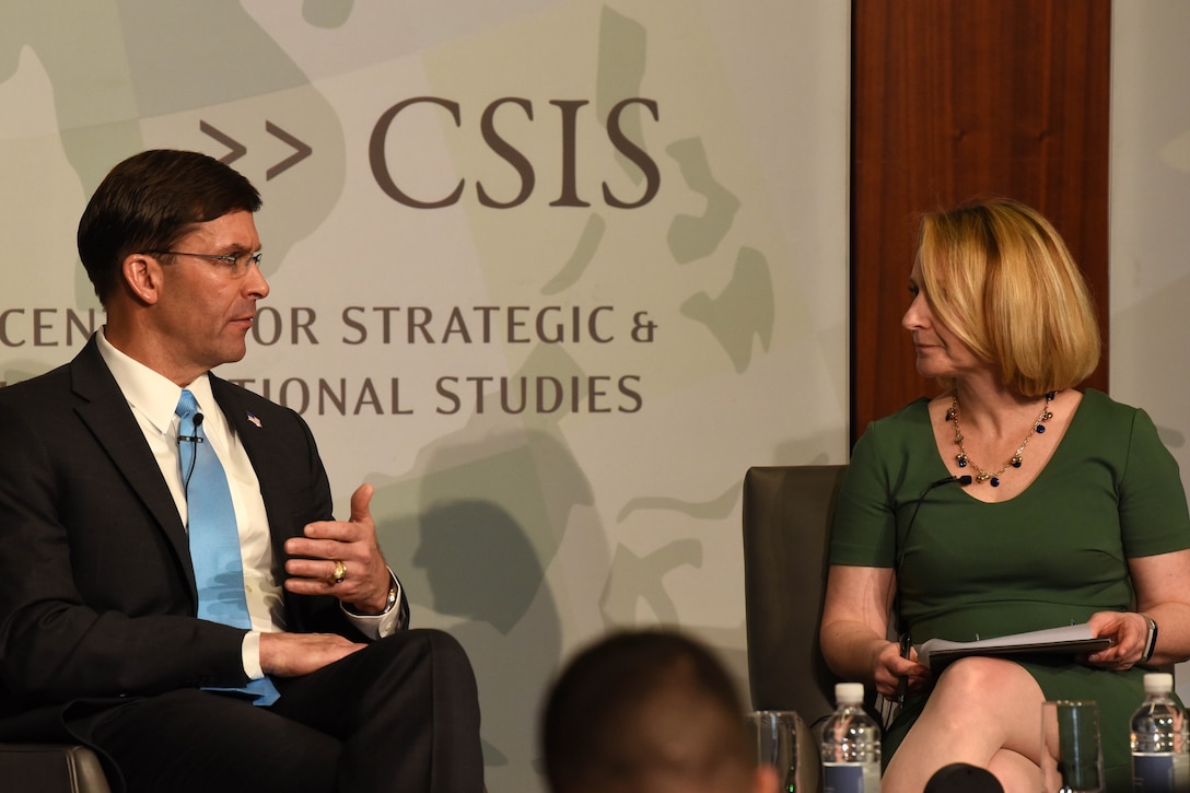 Defense Secretary Dr. Mark T. Esper speaks and a woman engage in a discussion before a group of people.