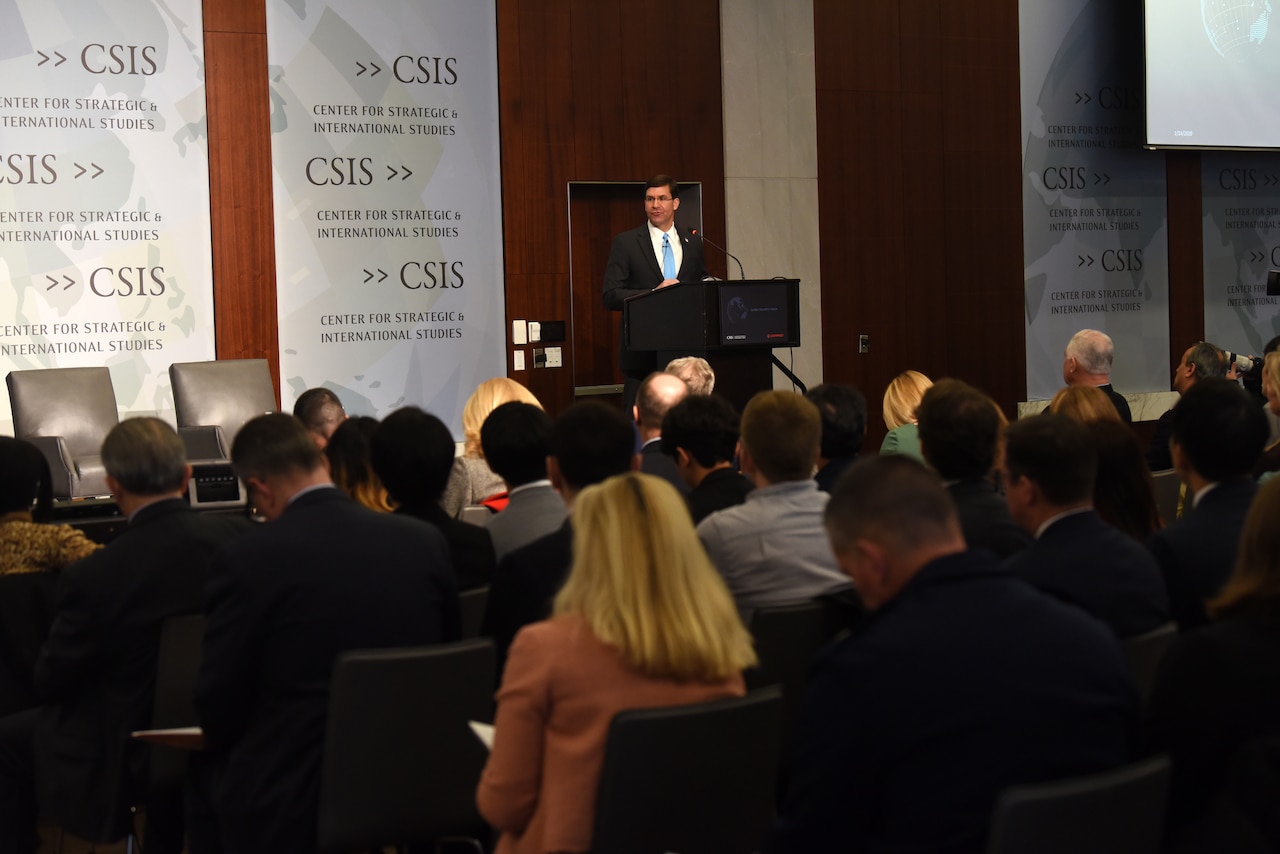 Defense Secretary Dr. Mark T. Esper speaks at a lectern on a stage; people sit in the audience.