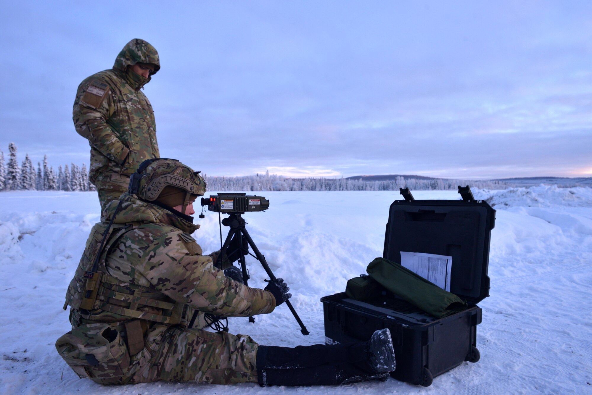 Staff Sgt. evaluates Airman 1st Class as he sets up a ground-portable laser target designator