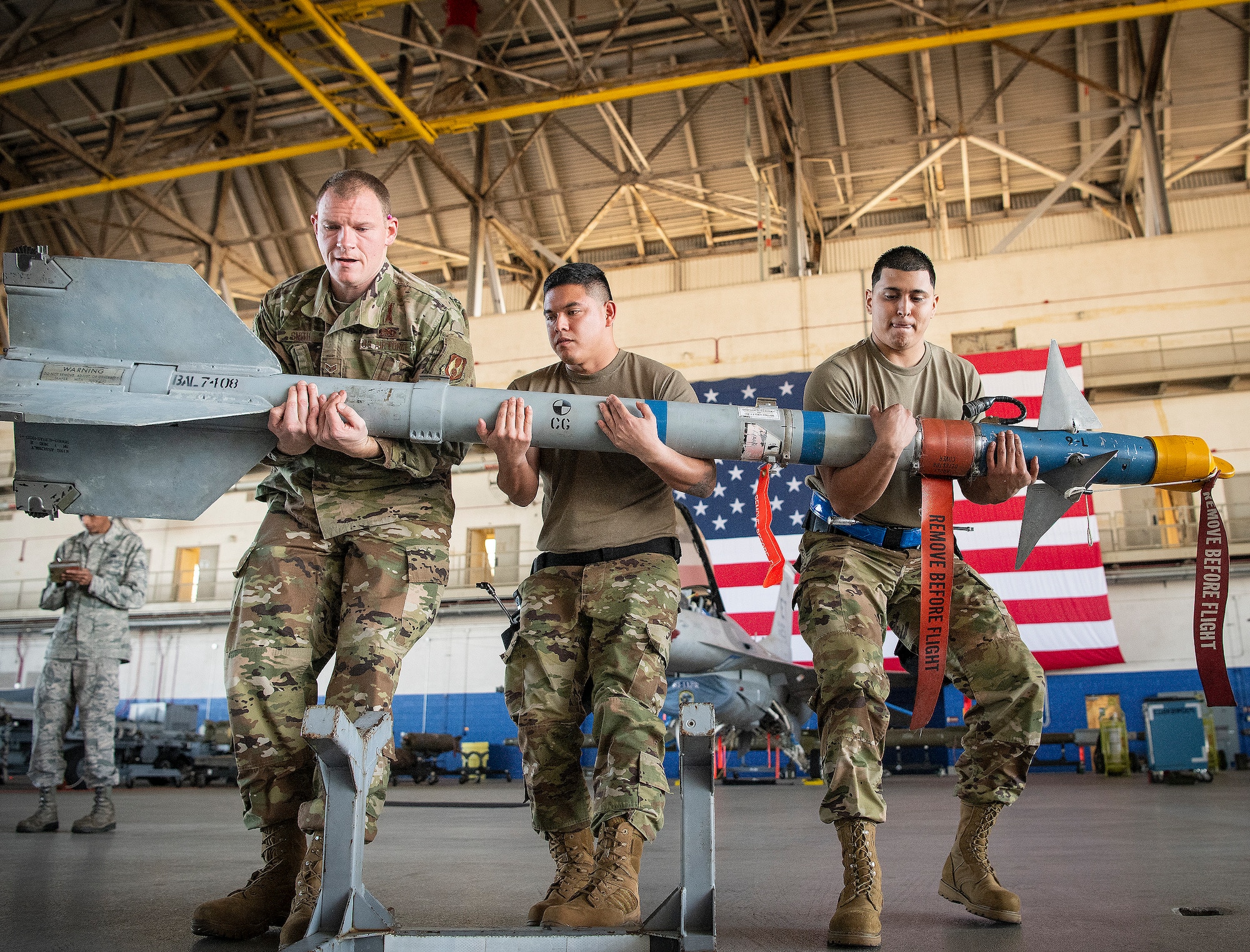 Airman lift an AIM-9X Sidewinder missile during weapons-load competition