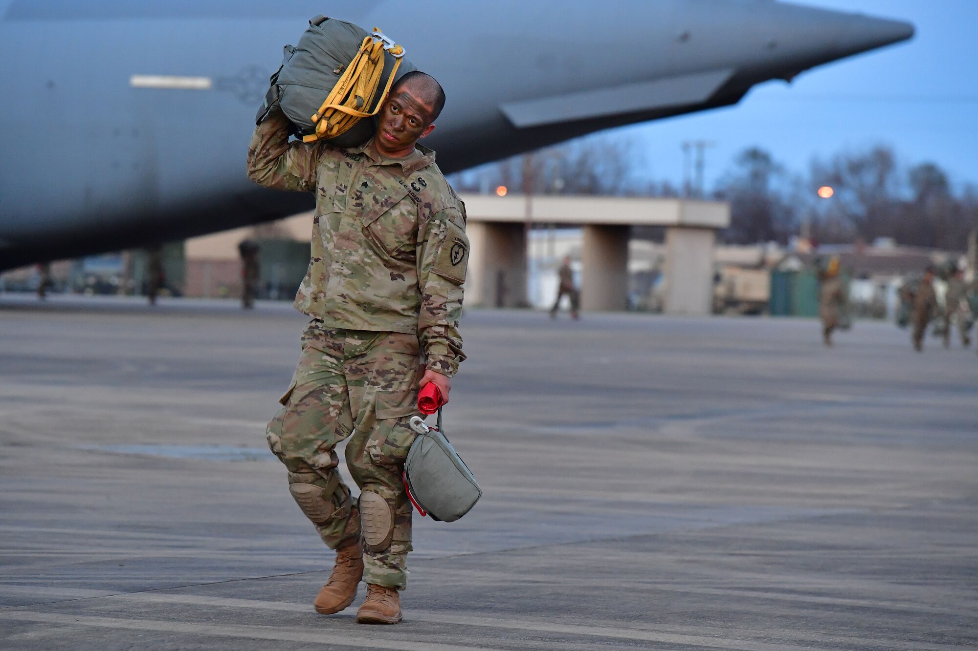 A soldier from the 4th Brigade Combat Team (Airborne), 25th Infantry Division, at Joint Base Elmendorf-Richardson, Alaska, walks to a C-17 Globemaster III during the joint forcible entry and airborne assault which kicked off Green Flag Little Rock 20-03.