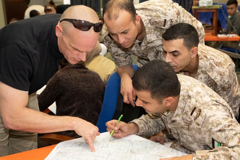 A U.S. Army Soldier (left), with 38th Infantry Division, Task Force Spartan, Indiana National Guard, locates map grid coordinates with Jordan Armed Forces-Arab Army (JAF) Soldiers during a Map Reading Subject Matter Expert Exchange with Military Engagement Team-Jordan, 158th Maneuver Enhancement Brigade, Arizona Army National Guard, at a base outside of Amman, Jordan Jan. 13, 2020. The United States is committed to the security of Jordan and to partnering closely with the JAF to meet common security challenges. (U.S. Army photo by Sgt. 1st Class Shaiyla B. Hakeem)