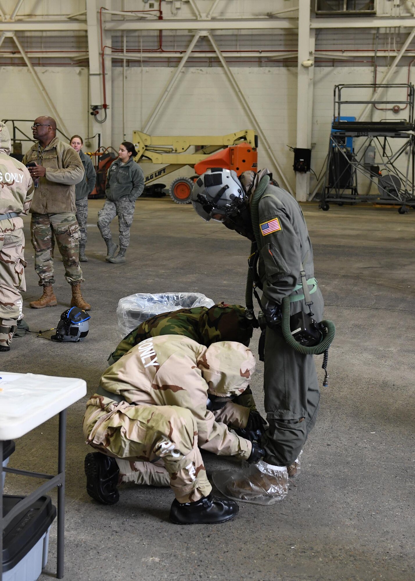 Two Airmen untie another Airman's boots.