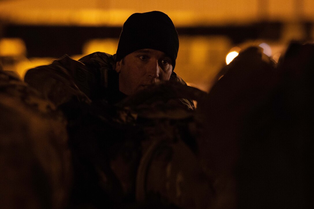 A soldier prepares items on a pallet.