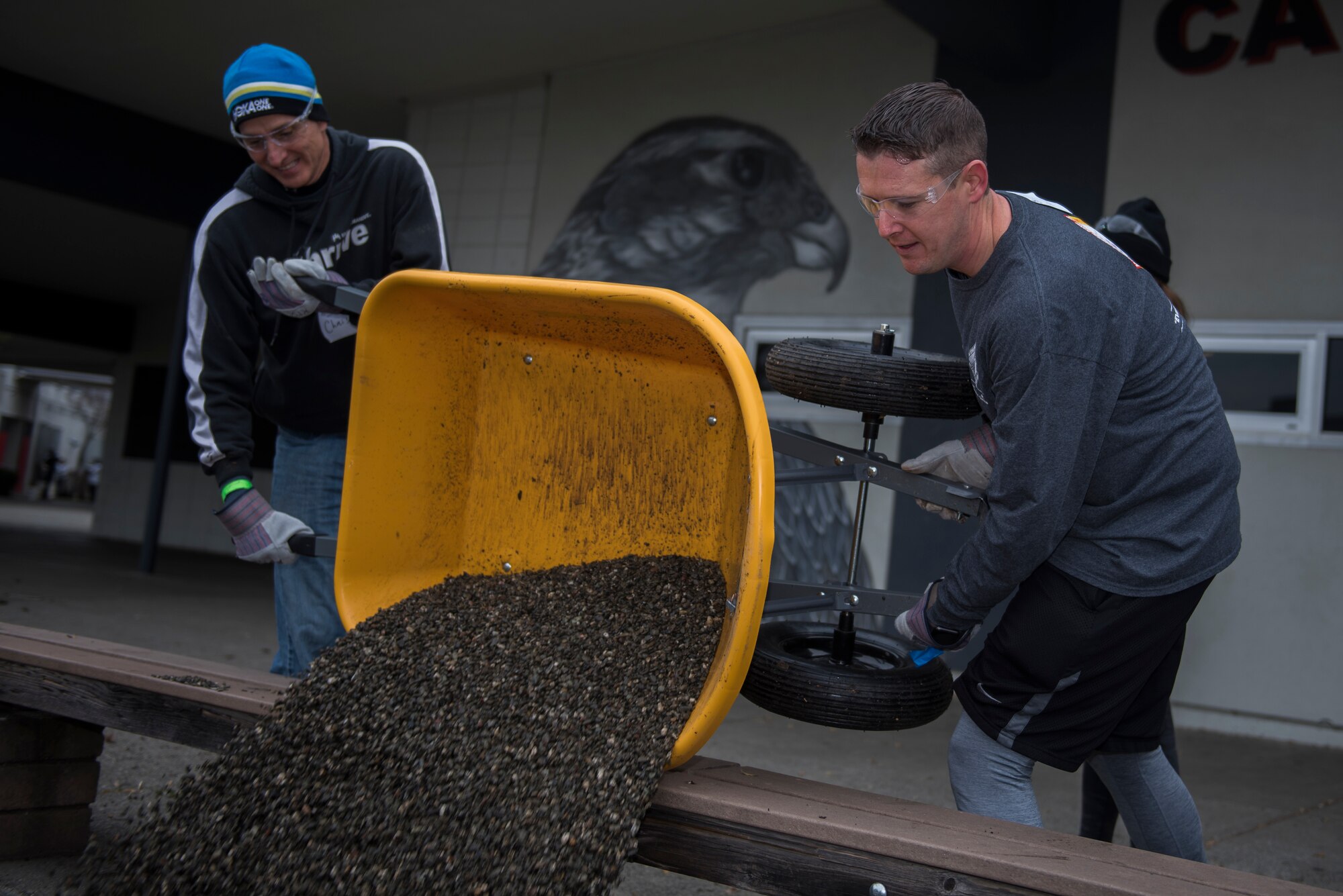 Chris Walker, left, Kaiser Permanente chief physician, and Andrew Muck, right, Kaiser Permanente strategic project leader, pour rocks over dirt for decoration Jan. 20, 2020, at Fairfield High School, Fairfield, California. The Rebuilding Together Solano County organization hosts an annual Martin Luther King Jr. Day of Service event where various volunteers help rebuild the community. This year marked their 11th annual Martin Luther King Jr. Day of Service event. More than 300 workers, including 31 Travis Airmen, volunteered to make their community a better and safer place. (U.S. Air Force photo by Airman 1st Class Cameron Otte)
