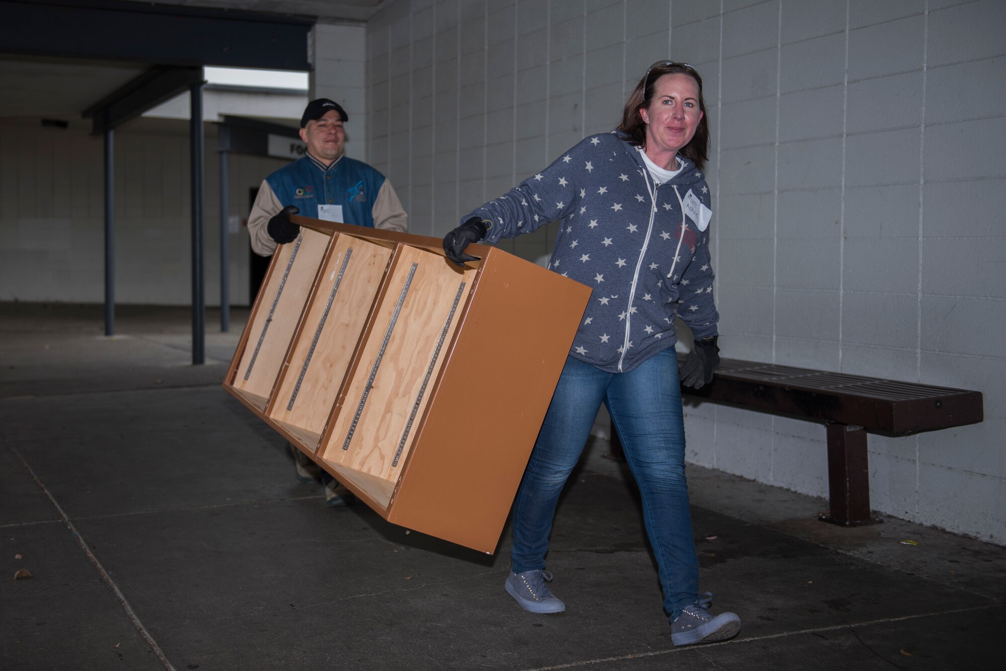 U.S. Air Force Airman 1st Class Luis Ortiz, left, 660th Aircraft Maintenance Squadron guidance and control specialist, and Tech. Sgt. Ashlie Steele, right, 60th Aerospace Medical Squadron bioenvironmental engineering, carry a bookshelf Jan. 20, 2020, at Fairfield High School, Fairfield, California. The Rebuilding Together Solano County organization hosts an annual Martin Luther King Jr. Day of Service event where various volunteers help rebuild the community. This year marked their 11th annual Martin Luther King Jr. Day of Service event. More than 300 workers, including 31 Travis Airmen, volunteered to make their community a better and safer place. (U.S. Air Force photo by Airman 1st Class Cameron Otte)
