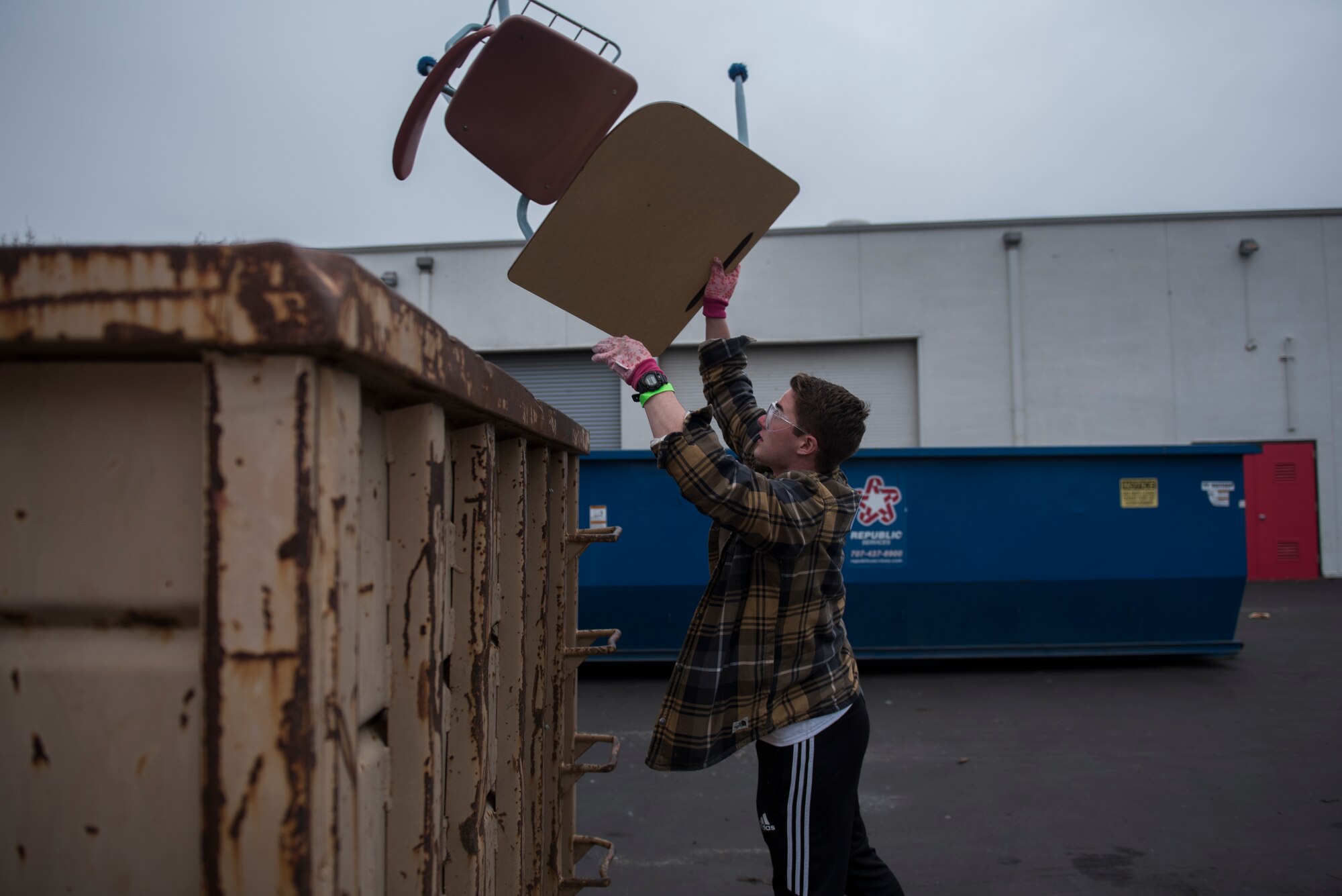 U.S. Air Force Airman 1st Class Dawson Moore, 22nd Airlift Squadron loadmaster, throws a damaged desk into a dumpster during a Martin Luther King Jr. Day of Service volunteer event Jan. 20, 2020, at Fairfield High School, Fairfield, California. The Rebuilding Together Solano County organization hosts an annual Martin Luther King Jr. Day of Service event where various volunteers help rebuild the community. This year marked their 11th annual Martin Luther King Jr. Day of Service event. More than 300 workers, including 31 Travis Airmen, volunteered to make their community a better and safer place. (U.S. Air Force photo by Airman 1st Class Cameron Otte)