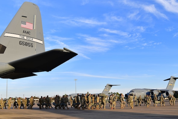 Soldiers from the 4th Brigade Combat Team (Airborne), 25th Infantry Division, at Joint Base Elmendorf-Richardson, Alaska, perform gear checks prior to boarding a C-130J Super Hercules during the joint forcible entry and airborne assault.