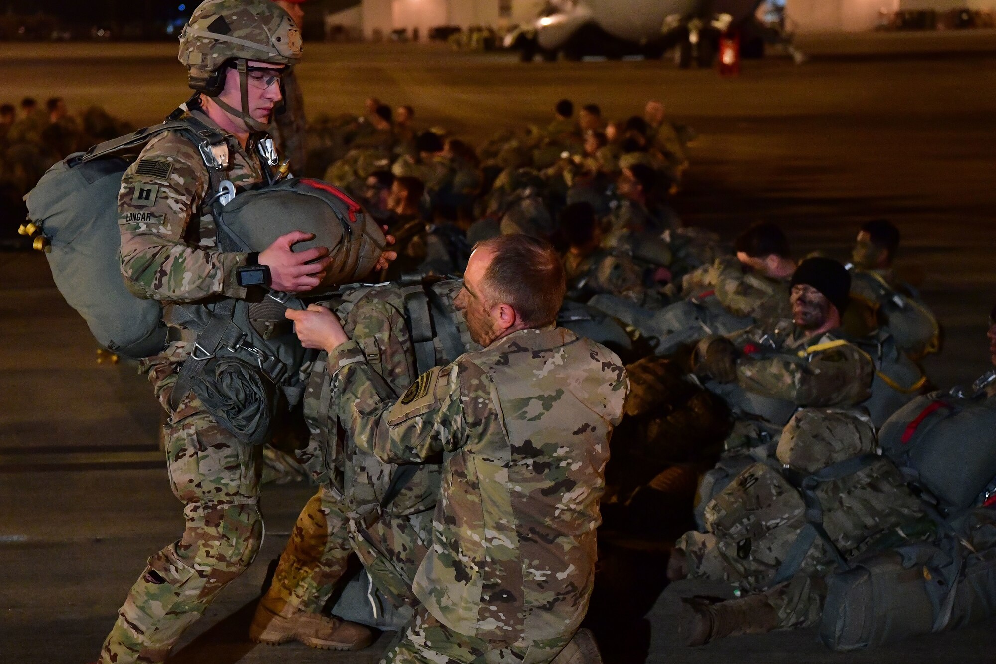 Soldiers from the 4th Brigade Combat Team (Airborne), 25th Infantry Division, at Joint Base Elmendorf-Richardson, Alaska, perform gear checks prior to boarding a C-130J Super Hercules during the joint forcible entry and airborne assault.