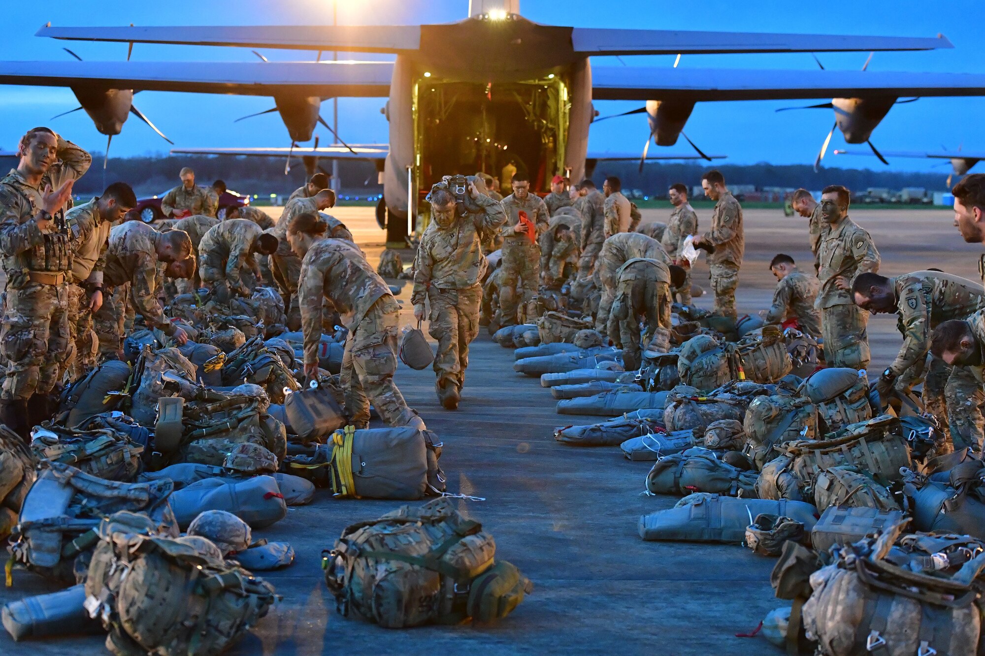 Soldiers from the 4th Brigade Combat Team (Airborne), 25th Infantry Division, at Joint Base Elmendorf-Richardson, Alaska, wait to board a C-130J Super Hercules during the joint forcible entry and airborne assault.