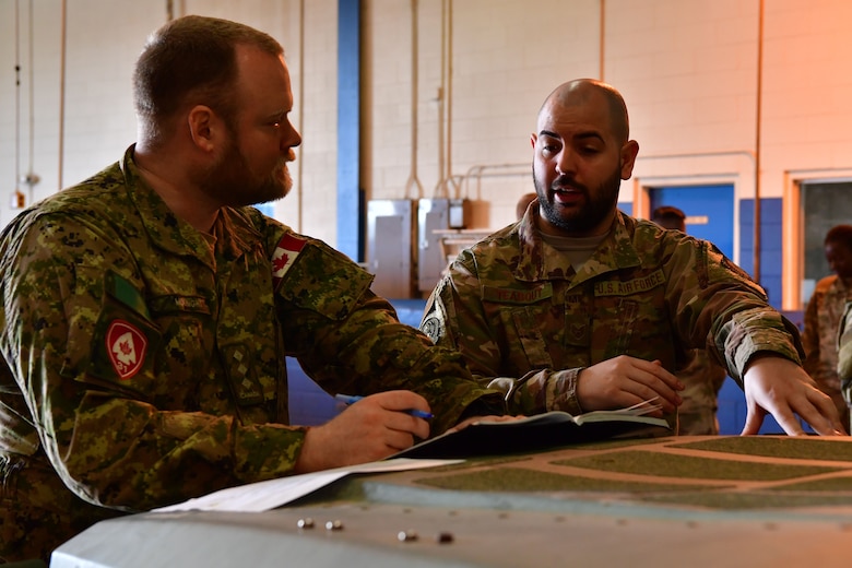 An Airman from the 621st Contingency Response Wing speaks with a member of the 31st Canadian Brigade Group before the joint forcible entry and airborne assault, which kicked off Green Flag Little Rock 20-03.