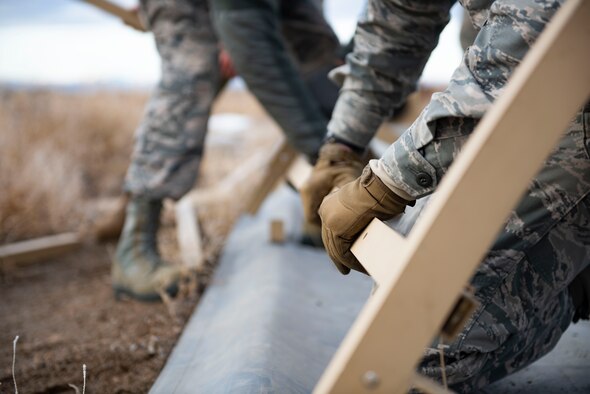 Airman from the 366th Civil Engineer Squadron use teamwork to construct a tactical shelter during the Base Emergency Engineer Force training, Jan. 23, 2020, at Mountain Home Air Force Base, Idaho. This training was conducted to equip Airman with skills from other career fields to enhance their readiness. (U.S. Air Force photo by Senior Airman Tyrell Hall