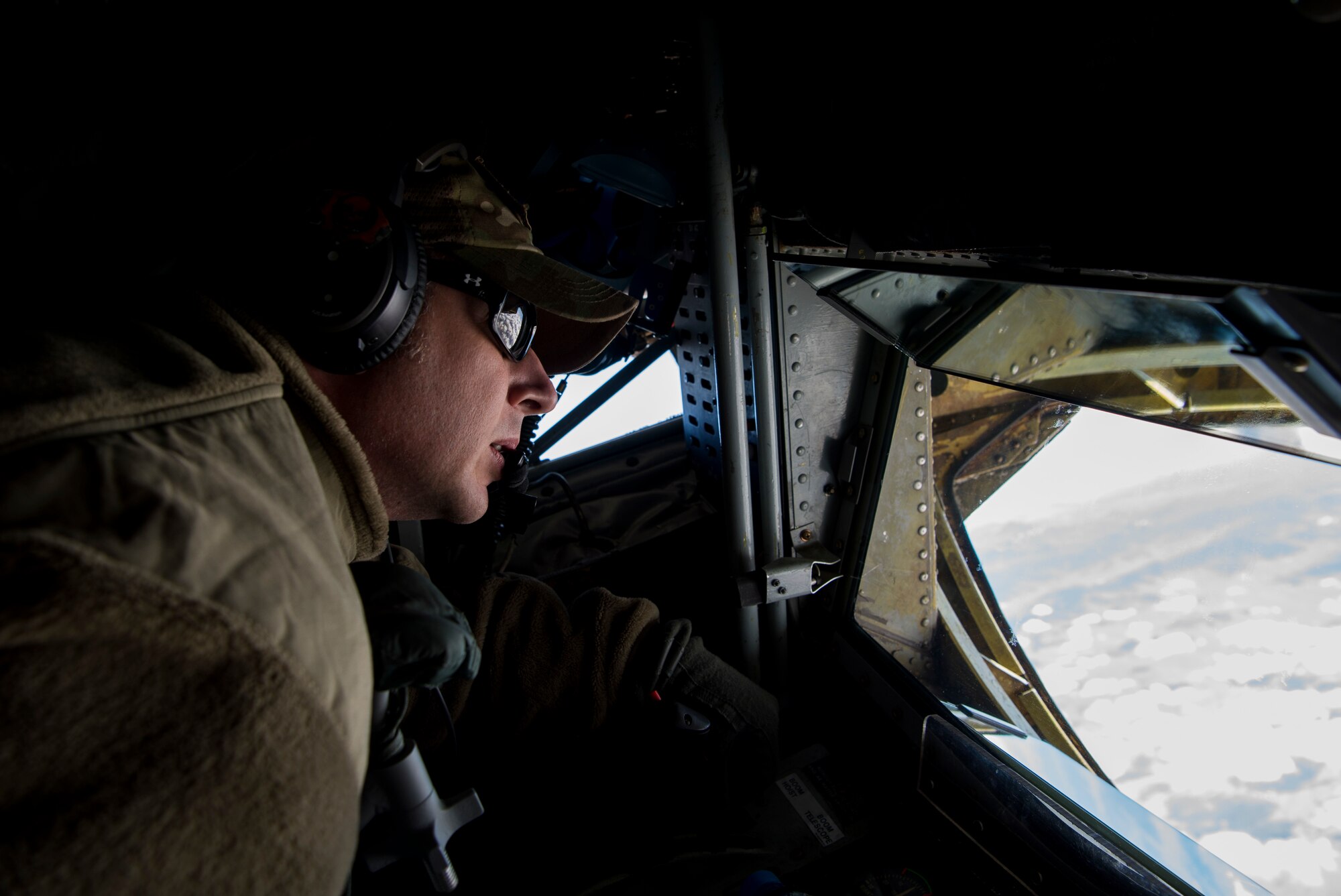 A U.S. Air Force in-flight refueling specialist assigned to the 28th Expeditionary Air Refueling Squadron scans the horizon from a KC-135 Stratotanker over Afghanistan, Jan. 14, 2020.