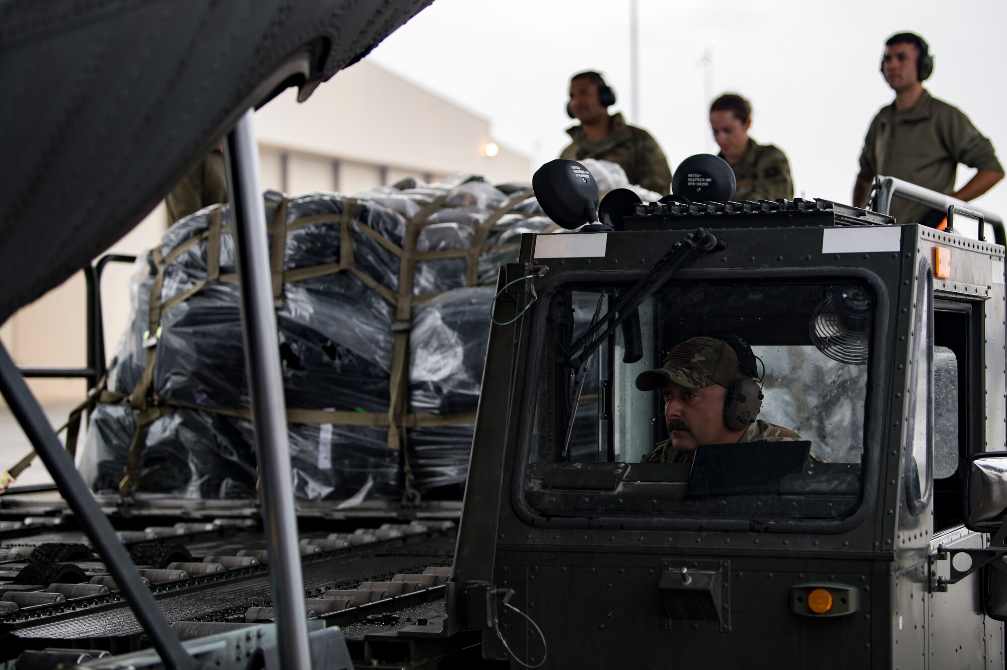 A U.S. Air Force aerial porter assigned to the 746th Expeditionary Logistics Readiness Squadron brings cargo to the ramp of a U.S. Air Force C-130 Hercules assigned to the 746th Expeditionary Airlift Squadron at Al Udeid Air Base, Qatar, Dec. 15, 2019.