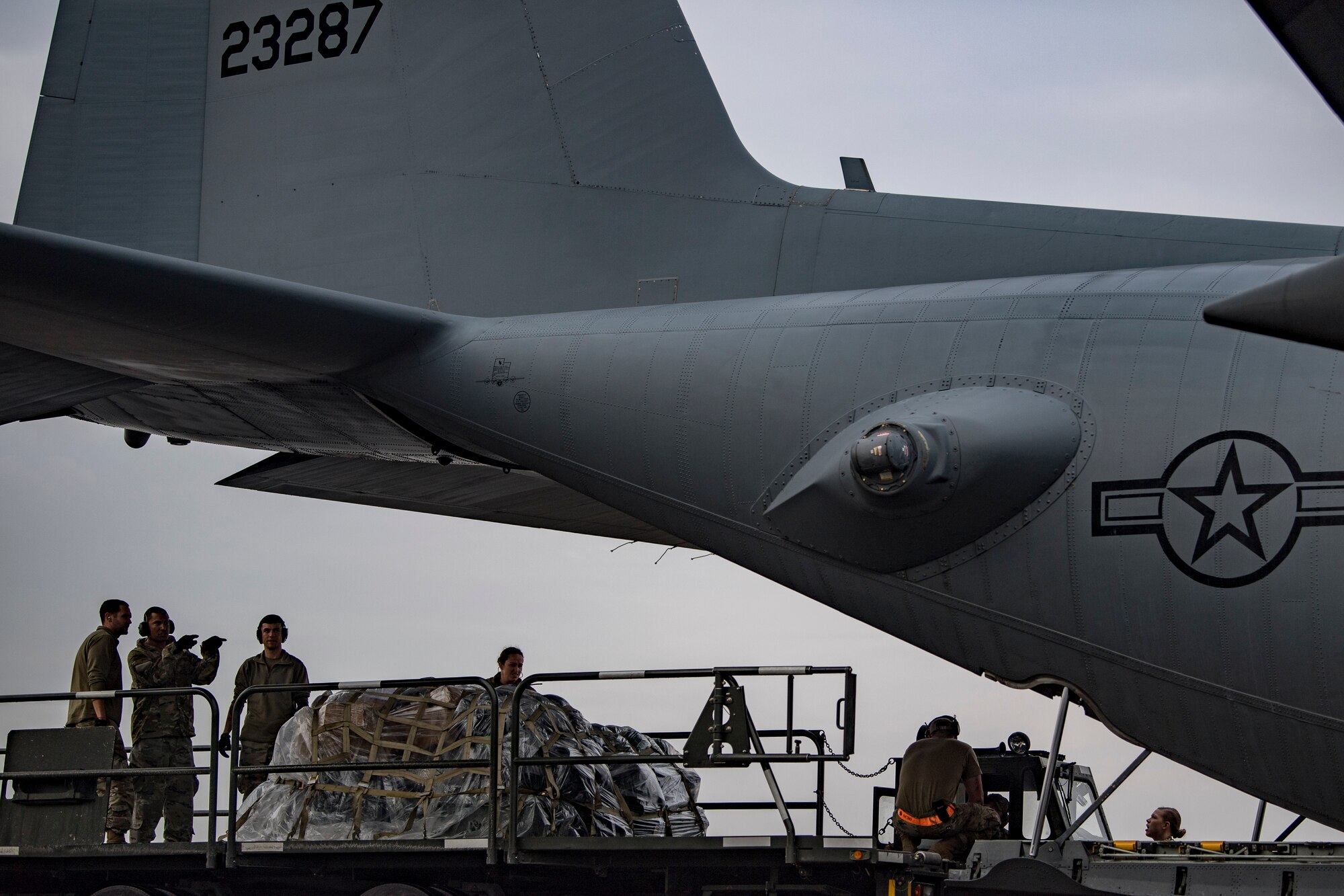 U.S. Air Force Airmen prepare to load cargo into a U.S. Air Force C-130 Hercules assigned to the 746th Expeditionary Airlift Squadron at Al Udeid Air Base, Qatar, Dec. 15, 2019.