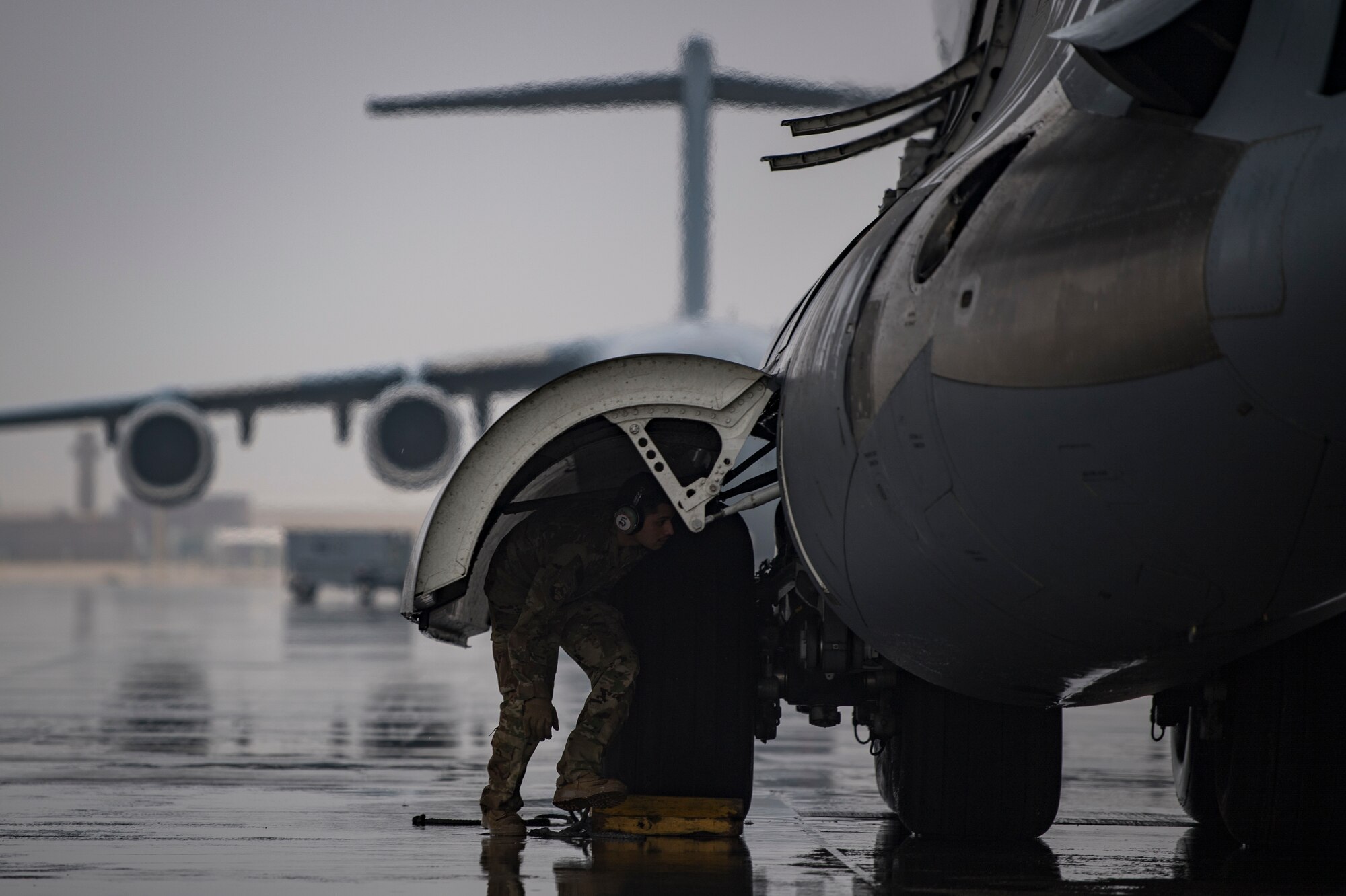 A U.S. Air Force flying crew chief assigned to the 816th Expeditionary Airlift Squadron conducts preflight checks of a U.S. Air Force C-17 Globemaster III at Al Udeid Air Base, Qatar, Jan. 10, 2020.