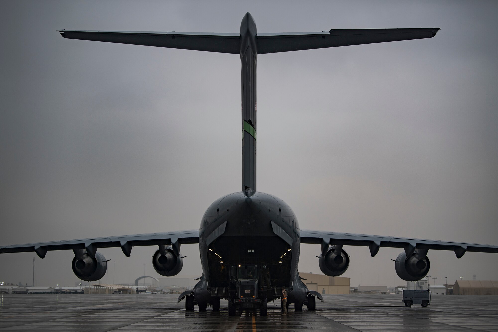 U.S. Air Force Airmen assigned to 746th Expeditionary Logistics Readiness Squadron load cargo into a C-17 Globemaster III assigned to the 816th Expeditionary Airlift Squadron at Al Udeid Air Base, Qatar, Jan. 10, 2020.