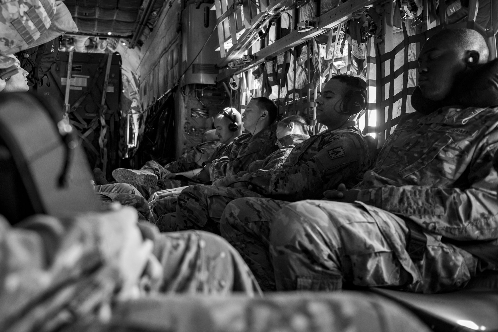 U.S. Air Force Airmen and U.S. Army Soldiers rest during flight aboard a U.S. Air Force C-130 Hercules assigned to the 746th Expeditionary Airlift Squadron above Saudi Arabia, Dec. 15, 2019.