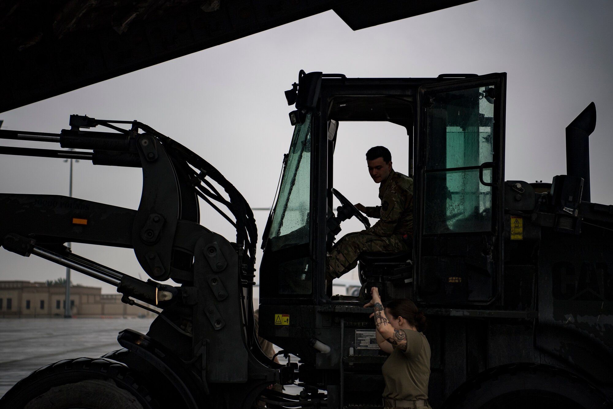 A U.S. Air Force loadmaster assigned to the 816th Expeditionary Airlift Squadron, bottom, guides a U.S. Air Force aerial porter assigned to the 746th Expeditionary Logistics Readiness Squadron transporting cargo to a U.S. Air Force C-17 Globemaster III at Al Udeid Air Base, Qatar, Jan. 10, 2020.