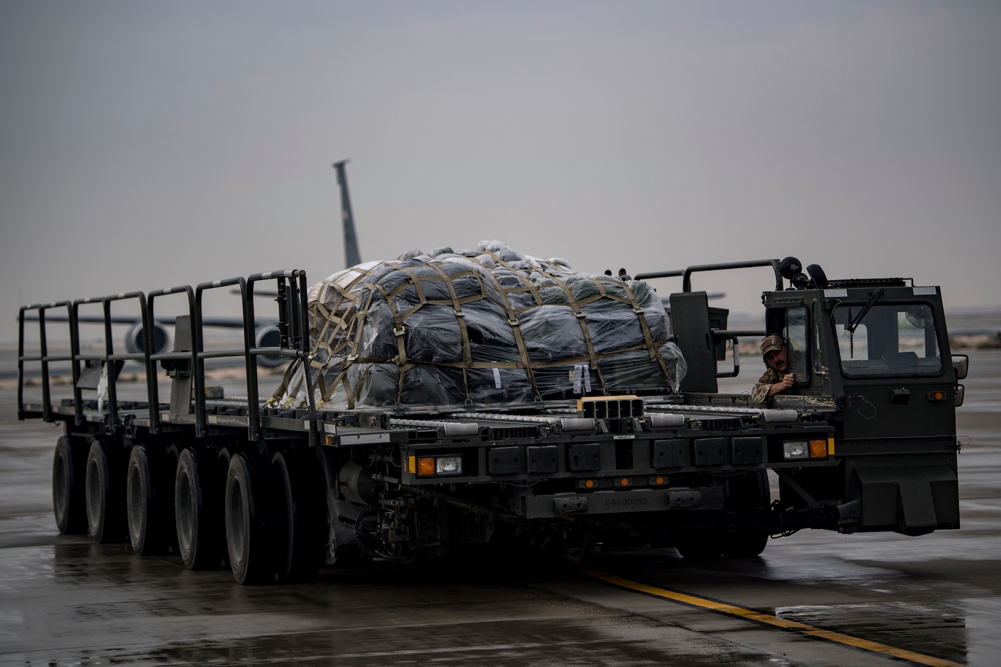 A U.S. Air Force aerial porter assigned to the 746th Expeditionary Logistics Readiness Squadron brings cargo to the ramp of a U.S. Air Force C-130 Hercules assigned to the 746th Expeditionary Airlift Squadron at Al Udeid Air Base, Qatar, Dec. 15, 2019.