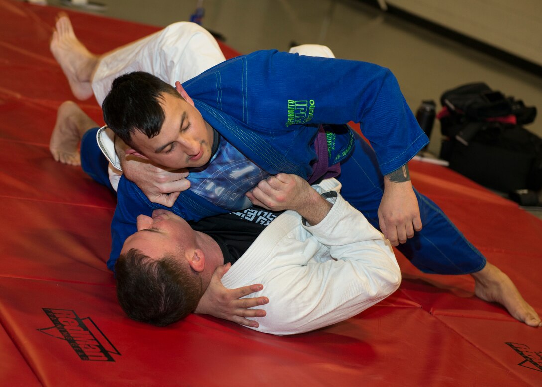 Master Sgt. Ian McMahon (top), 103rd Security Forces Squadron flight chief and combatives instructor, grapples with Tech. Sgt. Brian Davies, 103rd Security Forces Squadron, during an informal jiu-jitsu session at Bradley Air National Guard Base, East Granby, Conn. Jan. 23, 2020. The two are part of a group of Security Forces members that meets throughout the month during their physical training time to practice jiu-jitsu, building camaraderie between the members while utilizing combatives skills and outside experience in the martial art. (U.S. Air National Guard photo by Staff Sgt. Steven Tucker)