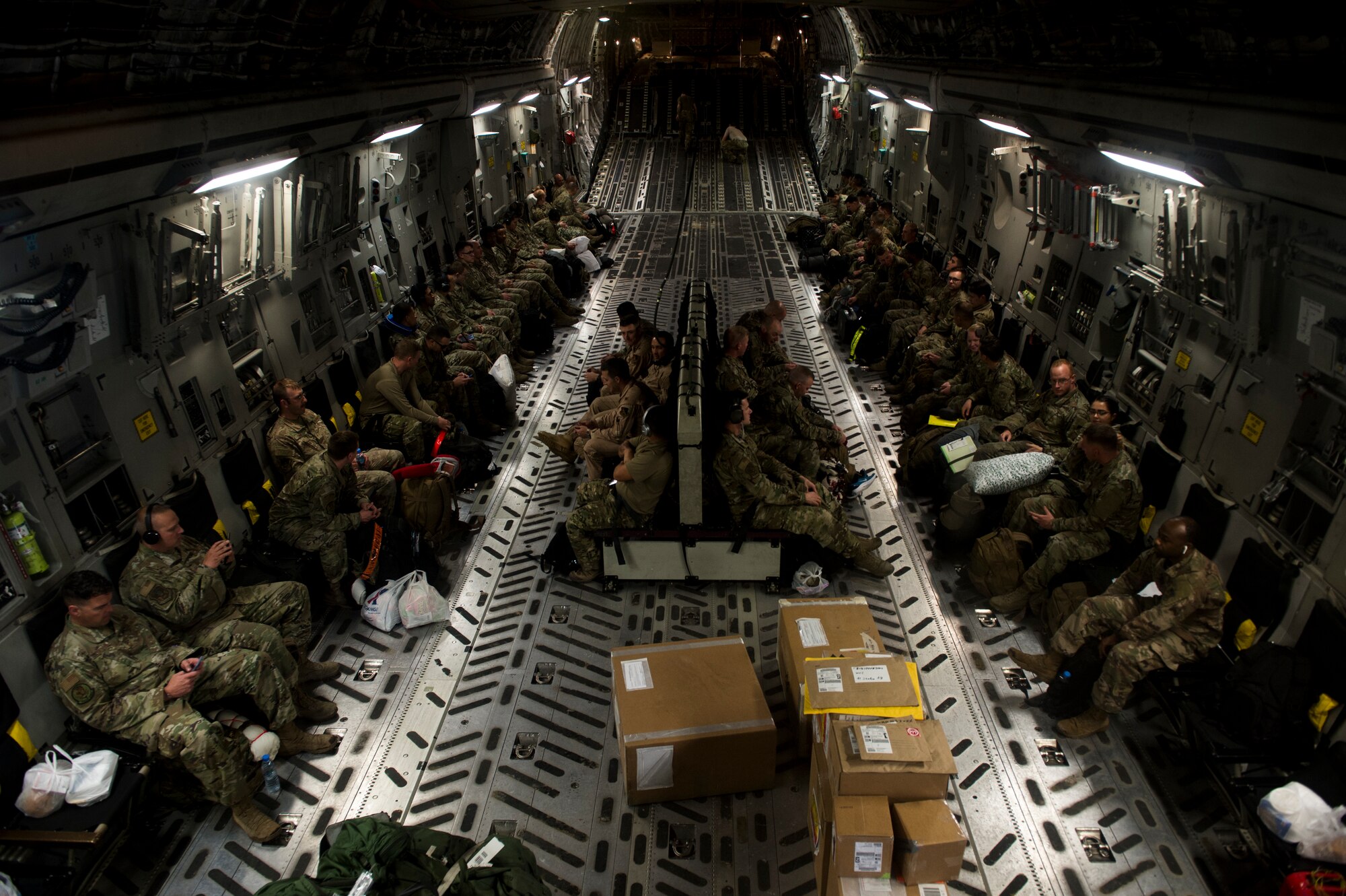 U.S. Air Force Airmen and aircrew wait for cargo to be loaded aboard a C-17 Globemaster III assigned to the 816th Expeditionary Airlift Squadron at Al Udeid Air Base, Qatar, Jan. 10, 2020.
