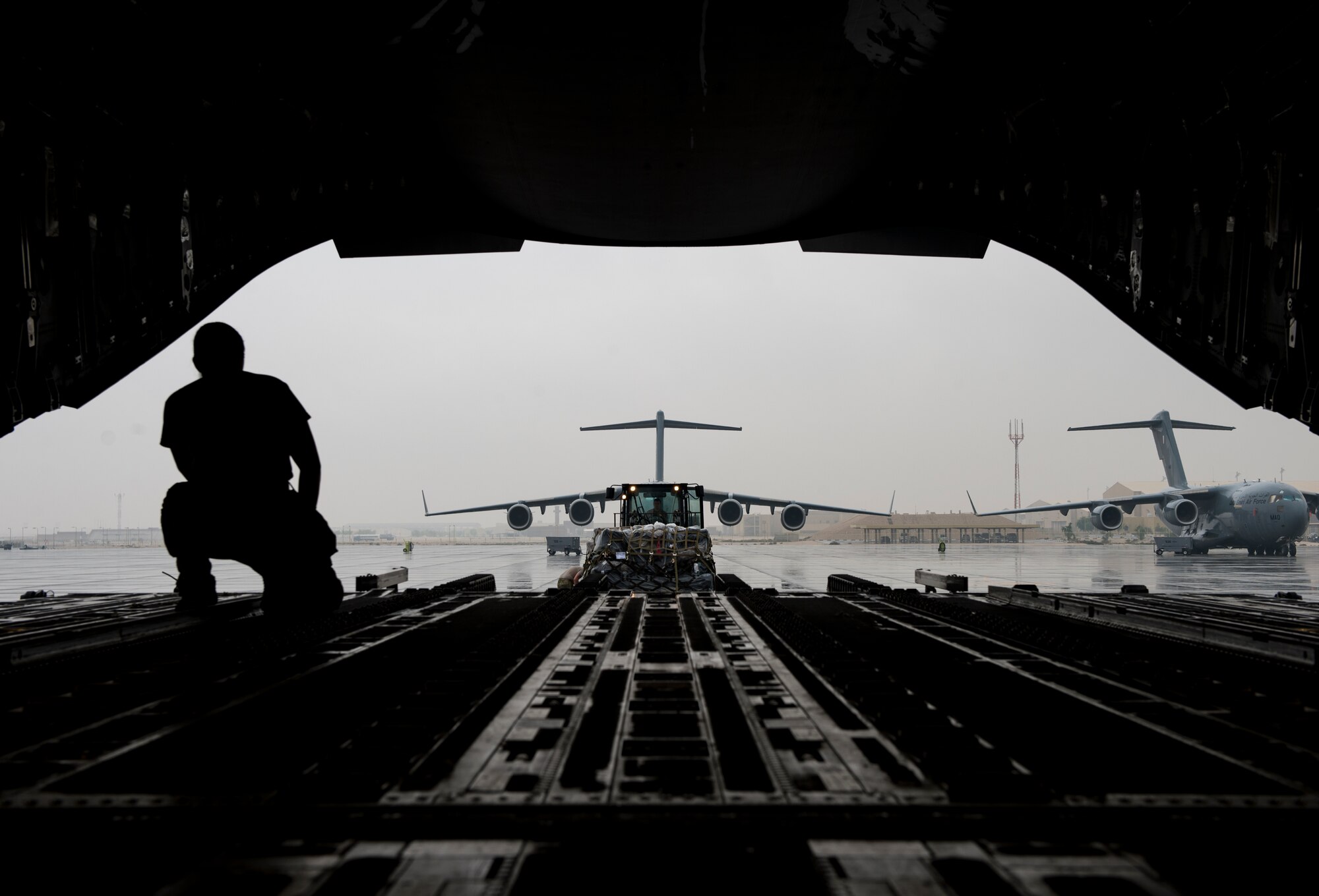 A U.S. Air Force loadmaster assigned to the 816th Expeditionary Airlift Squadron directs a forklift toward a C-17 Globemaster III at Al Udeid Air Base, Qatar, Jan. 10, 2020.