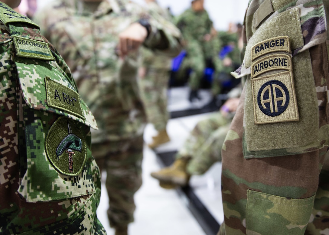 A U.S. Army 82nd Airborne Division and Colombian Army 2nd Special Forces Battalion Paratrooper stand next to each other.