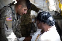U.S. Army Sgt. Manuel Solloso, assigned to 546th Area Support Medical Company bandages a role player in a simulated mass casualty decontamination line at Travis County Exposition Center as part of Exercise Sudden Response 20.