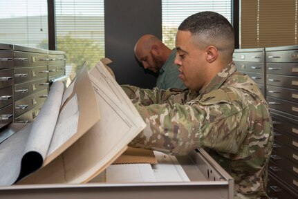 Staff Sgt. Aaron Williams, team lead for the 628th Civil Engineering Squadron’s Weapons Station geo-integrations office, looks over the detail of a of a building’s blueprint