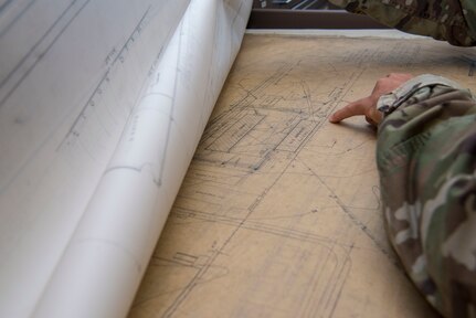 Staff Sgt. Aaron Williams, team lead for the 628th Civil Engineering Squadron’s Weapons Station geo-integrations office, looks over the detail of a of a building’s blueprint