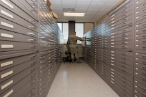 Staff Sgt. Aaron Williams, team lead for the 628th Civil Engineering Squadron’s Weapons Station geo-integrations office, and Caleb Brewer, the 628th CES geo-based program manager, look at previous computer aided drawings and blueprints for buildings