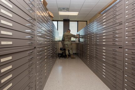 Staff Sgt. Aaron Williams, team lead for the 628th Civil Engineering Squadron’s Weapons Station geo-integrations office, and Caleb Brewer, the 628th CES geo-based program manager, look at previous computer aided drawings and blueprints for buildings