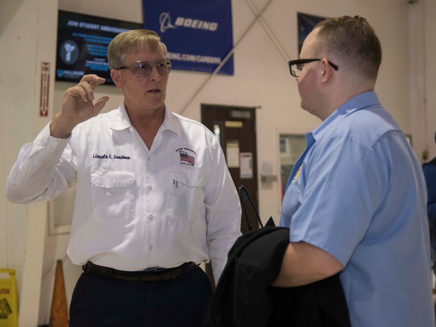 William Brabbin, a 12th Maintenance Group new hire, and Lincoln Sundman, 12th Maintenance Group T-1/T-6 Aircraft Maintenance Unit branch chief, Joint Base San Antonio-Randolph, have a discussion at the Hallmark University College of Aeronautics graduation ceremony Jan. 23, 2020. Brabbin was hired as part of the of the 12th MXG’s push for recruitment and new employees for the upcoming missions slated for JBSA-Randolph.