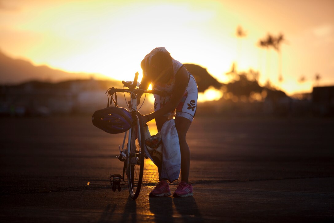 Cristol M. Vasser cleans off the frame of her bike prior to the start of the Keiki and Koa Kai Sprint Triathlon at Hangar 101, aboard Marine Corps Air Station, Kaneohe Bay, Hawaii, May 1.