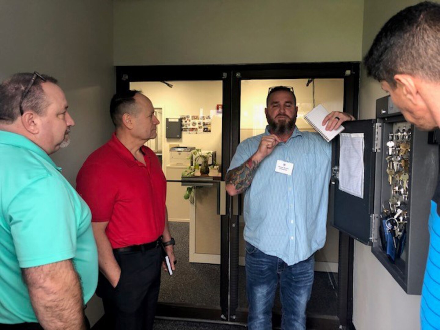DLA Disposition Services Operations Director, Arthur Welsh, (far left), DLA Disposition Services Chief of Staff, Pete Foreman, (left center) and Jacksonville Wage Supervisor, Jose De La Cruz, (far right) listen as Jacksonville Area Manager, Mike Brower, discusses key control procedures.