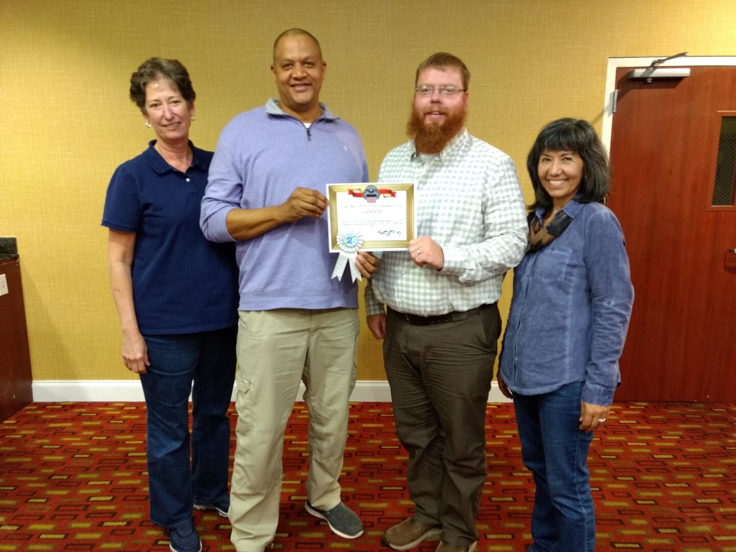 — Area Manager Kevin Vaughn (left center) and Warehouse Supervisor Lucas Grant (right center accept the second place site award from South-East Deputy Director Audrey Weber (far left) and South-East Director Kathy Atkins-Nuñez (far right).