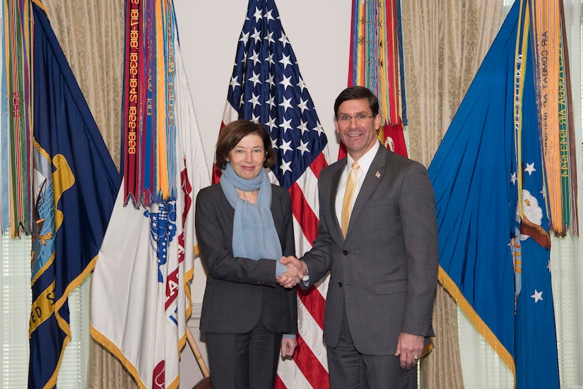 Defense Secretary Dr. Mark T. Esper shakes hands with his French counterpart in front of the American flag and several others flags.