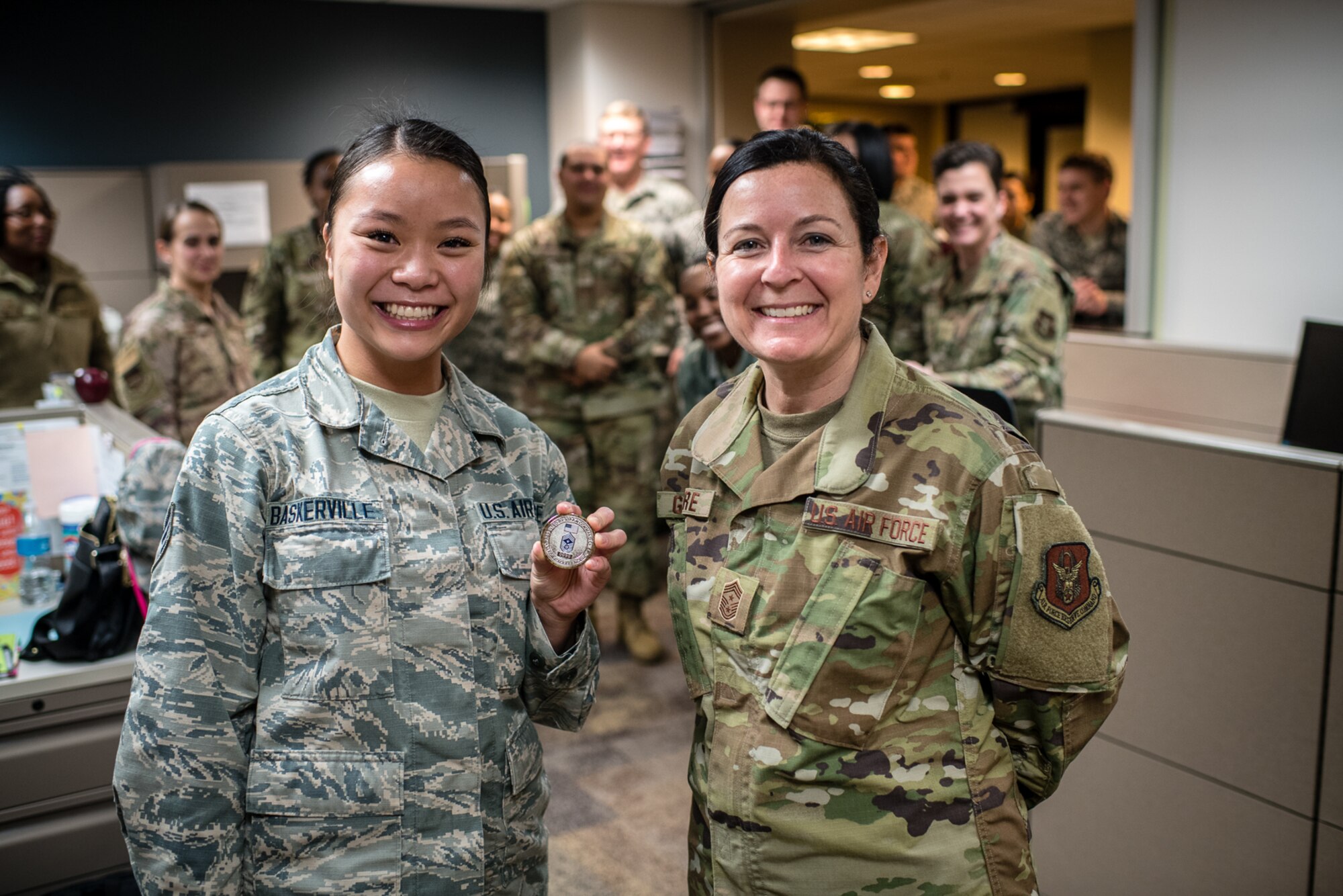 U.S. Air Force Citizen Airman, Senior Airman Kathryn N. Baskerville, 932nd Force Support Squadron, customer support technician  receives a Wing coin from 932nd Airlift Wing Command Chief, Barbara Gilmore for overall excellence in service and Baskervilles's recent graduation from Airmen Leadership School, Jan. 10, 2020, Scott Air Force Base, Illinois. (U.S. Air Force photo by Christopher Parr)