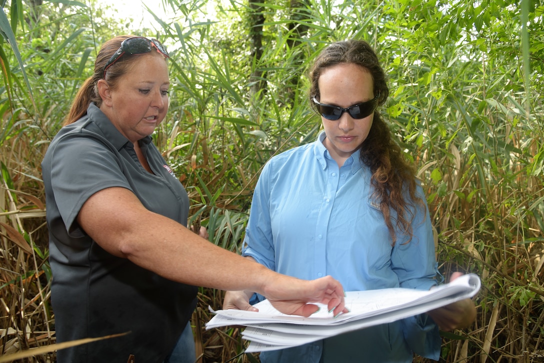 Members of Norfolk District talk alongside proposed site for restoration near a body of water