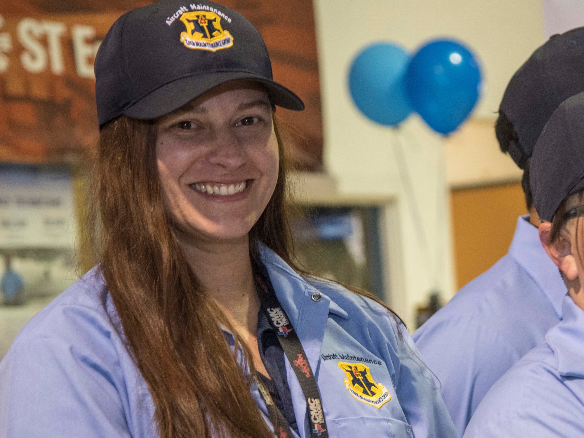 Katherine Longest, a new hire for the 12th Maintenance Group, Joint Base San Antonio-Randolph, smiles in newly issued 12th MXG apparel during her graduation ceremony Jan. 23, 2020, at the Hallmark University College of Aeronautics, San Antonio. Longest was one of the seven 12th MXG new hires recruited from her graduating class.