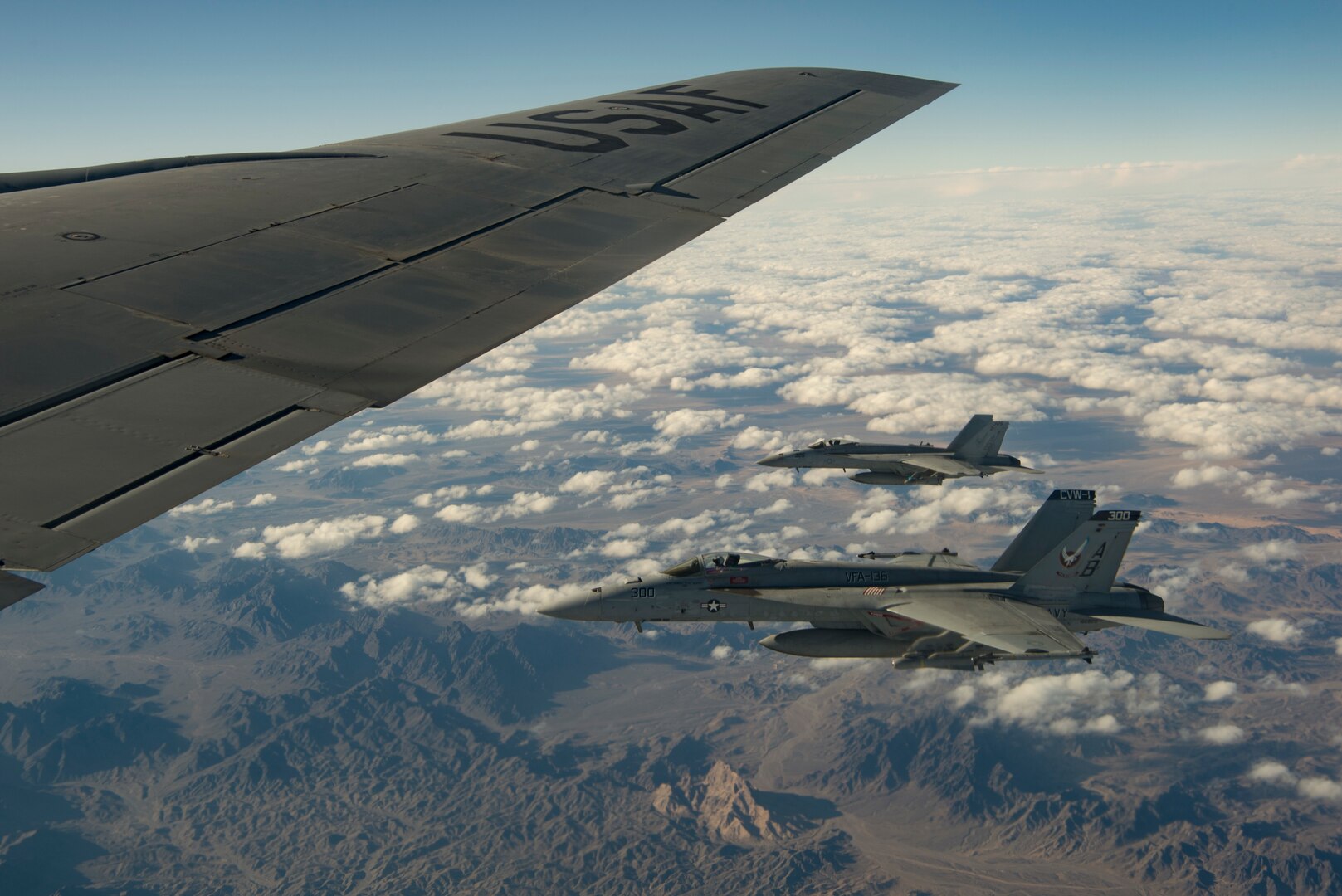 Two U.S. Navy F/A-18 Super Hornet fly alongside a KC-135 Stratotanker assigned to the 28th Expeditionary Air Refueling Squadron over Afghanistan, Jan. 14, 2020.