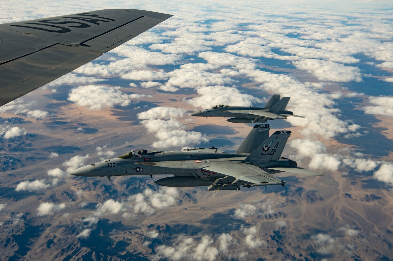 Two U.S. Navy F/A-18 Super Hornet fly alongside a KC-135 Stratotanker assigned to the 28th Expeditionary Air Refueling Squadron over Afghanistan, Jan. 14, 2020.