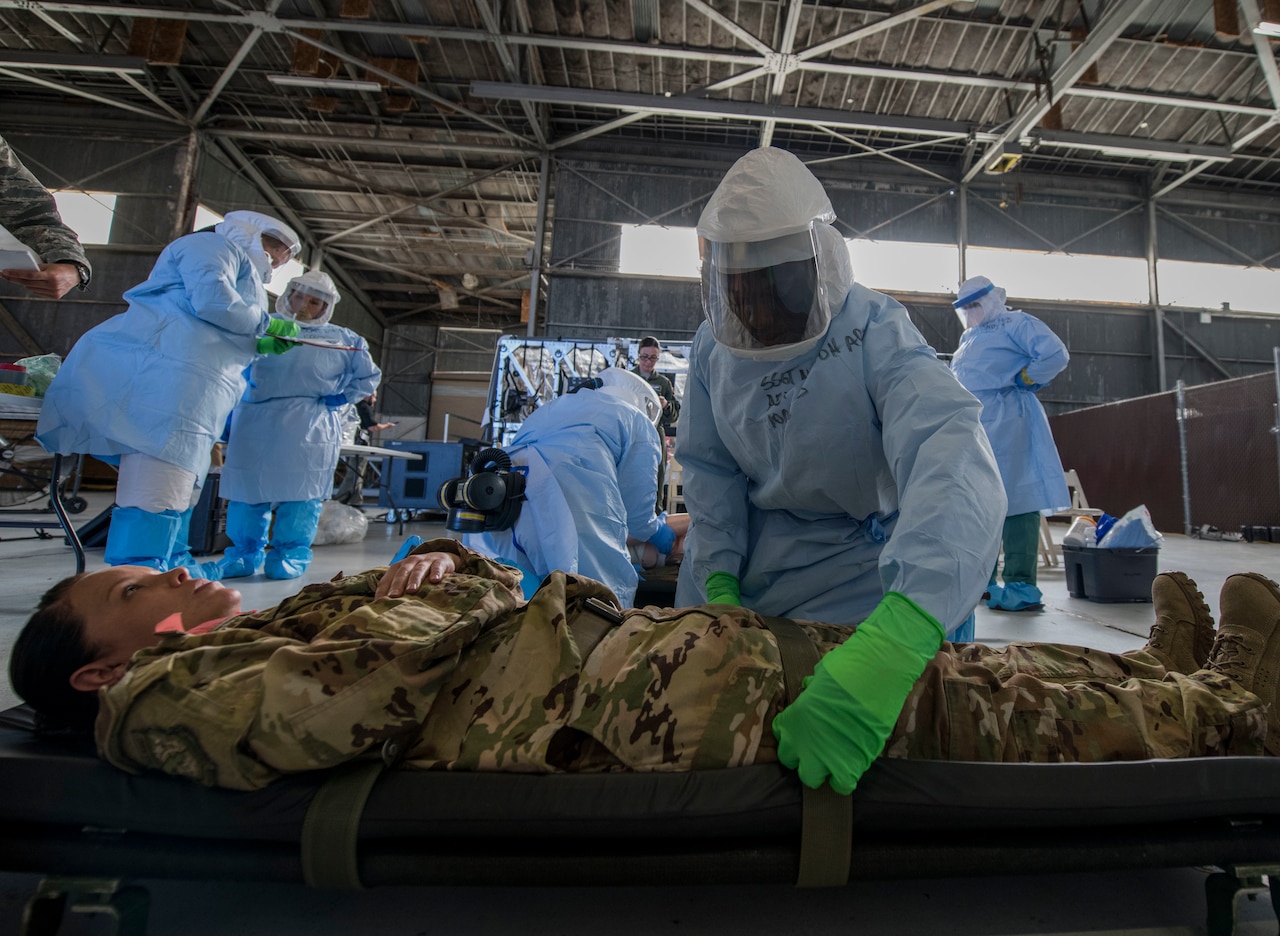 An airman straps a simulated Ebola patient to a litter during a Transport Isolation System training exercise at Joint Base Charleston, S.C.