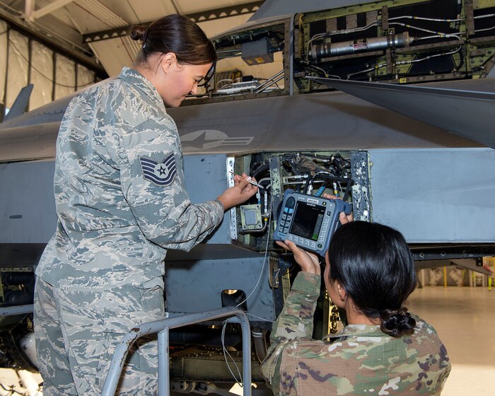 Tech. Sgt. Rosa Valdes and Staff Sgt. Rebecca Toland, non-destructive inspection technicians from the 140th Maintenance Squadron, perform an inspection of the 446 bulkhead on a block-30 F-16 Fighting Falcon aircraft. The 446 bulkhead is aft fuselage structure of the F-16 aircraft that supports the tail structure and recent tests have indicated an increased amount of stress cracks in this area.