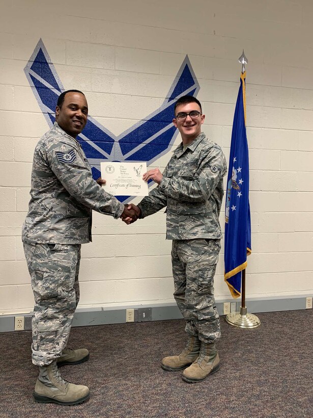 Airman Joshua Olesen, 365th Training Squadron instrument flight control systems apprentice course graduate, left, receives his completion of training certificate at Sheppard Air Force Base, Texas. (Courtesy photo)
